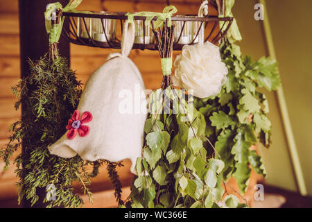 La Betulla, ginepro,quercia sauna accompagna scope ( noto anche come vasta, vihta o venik) appesi ed essiccamento. Sentivo la donna sauna hat a spugna. Sauna hat mantiene Foto Stock