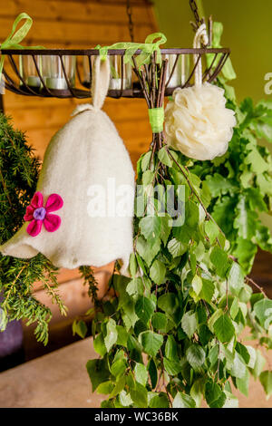 La Betulla, ginepro,quercia sauna accompagna scope ( noto anche come vasta, vihta o venik) appesi ed essiccamento. Sentivo la donna sauna hat a spugna. Sauna hat mantiene Foto Stock