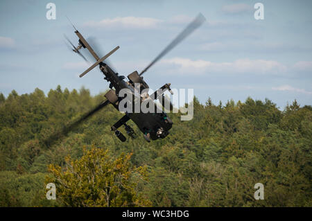 Un AH-64 Attacco Apache elicottero con il 1° Stormo, 6° reggimento di cavalleria, 1a combattere la Brigata Aerea, 1a Divisione di Fanteria alle banche di sinistra dopo scouting una posizione nella "scatola", come parte della forza culminante in esercizio di forza combinata di risolvere XII alla multinazionale comune disponibilità centro in Hohenfels, Germania Agosto 22, 2019. Risolvere combinato è un biennale U.S. Esercito in Europa e il settimo Esercito di formazione comando-led esercizio destinato a valutare e certificare la disponibilità e l'interoperabilità di noi le forze mobilitate in Europa a sostegno di Atlantic risolvere. (U.S. Esercito foto di Sgt. Thomas Foto Stock