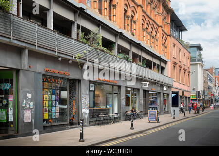 Negozi e caffetterie in Oldham Street nel quartiere settentrionale area di Manchester, UK. Foto Stock