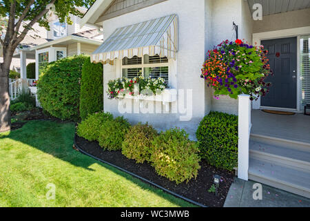 Finestra e ingresso principale della casa residenziale con sportello passi sulla giornata di sole Foto Stock