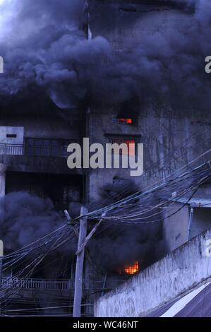 Il fumo e fiamme ondeggianti da un materasso factory fire, Steung Meanchey, Phnom Penh Cambogia. Credito: Kraig Lieb Foto Stock