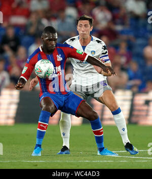 Il palazzo di cristallo di Benteke cristiana e Colchester Regno di Luca Prosser (destra) battaglia per la sfera durante il Carabao Cup secondo turno corrispondono a Selhurst Park, Londra. Foto Stock