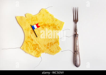 Cucina francese concetto crêpe in forma di Francia con la bandiera francese sul tavolo bianco con forcella vintage Foto Stock