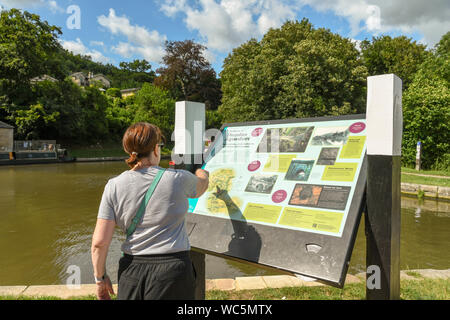 Bagno, Inghilterra - Luglio 2019: Persona che punta a qualcosa su una bacheca con informazioni per i visitatori di Dundas Aquaduct sul Kennet & Avon Canal n Foto Stock