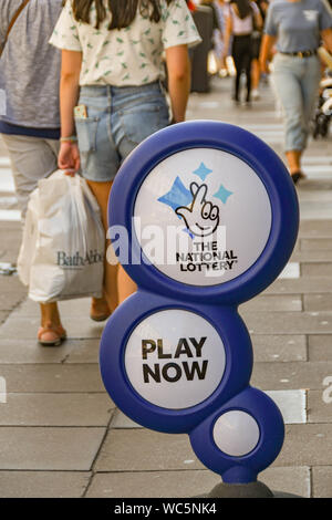 Bagno, Inghilterra - Luglio 2019: segno pubblicità la lotteria nazionale al di fuori di un negozio su una strada nel centro di Bath. Foto Stock