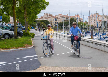 La Rochelle, Francia - 7 Maggio 2019: coppia di anziani passeggiate in bici vicino a Port des Minimes a La Rochelle, Francia Foto Stock