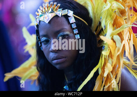 Ballerino femmina indossando piume al carnevale di Notting Hill a Londra, la più grande strada di carnevale in Europa Foto Stock