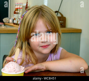 Giovane ragazza inglese - 5 anni - circa per gustare un gelato. Foto Stock