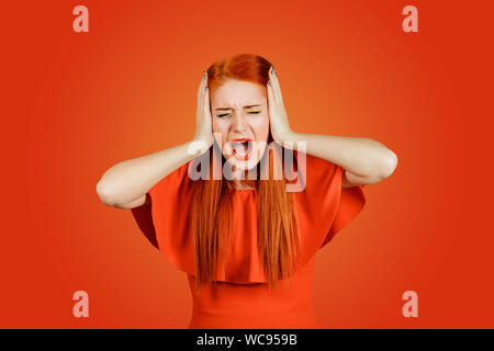 Ritratto arrabbiato ragazza adolescente donna urlare, bocca spalancata, isterico isolato sfondo rosso. Negativo volto umano espressioni, emozione, bad feeli Foto Stock