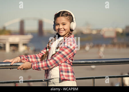 Infanzia felice. Autunno umore in cuffia per Pretty girl. Felice bambina ascoltare musica. Un bambino piccolo con sorriso. primavera e autunno moda. musica preferita con le cuffie. autunno vibes Foto Stock