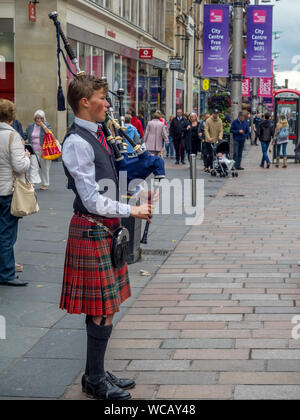 Un bagpiper su Buchanan Street sulla luglio 21, 2017 a Glasgow, in Scozia. Buchanan Street è una destinazione turistica popolare e quindi non vi è sempre una zampogna Foto Stock