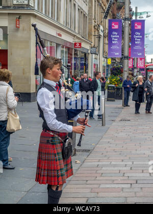 Un bagpiper su Buchanan Street sulla luglio 21, 2017 a Glasgow, in Scozia. Buchanan Street è una destinazione turistica popolare e quindi non vi è sempre una zampogna Foto Stock