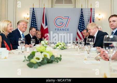 Stati Uniti Presidente Donald Trump, sinistra, detiene una colazione di lavoro con il Primo Ministro britannico Boris Johnson e le loro delegazioni a margine del vertice del G7 l'Hotel du Palais Biarritz Agosto 25, 2019 a Biarritz, Francia. Foto Stock