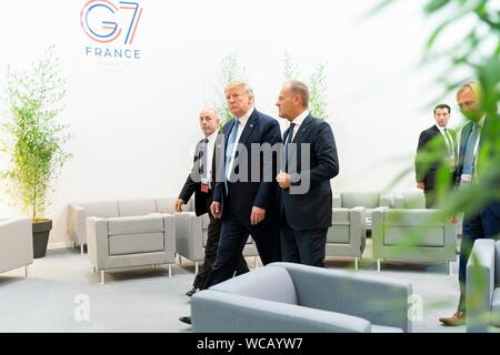 Stati Uniti Presidente Donald Trump, centro, le passeggiate con il Presidente del Consiglio europeo Donald Tusk, destra, prima dell'inizio di un G7 sessione di lavoro sulla economia globale, la politica estera e gli affari di sicurezza al centro de Congrés Bellevue Agosto 25, 2019 a Biarritz, Francia. Foto Stock