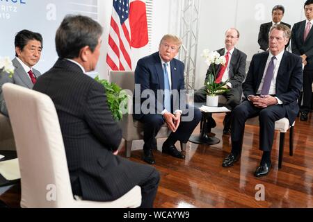 Stati Uniti Presidente Donald Trump ascolta l economia giapponese Ministro Toshimitsu Motegi, sinistra, come in Giappone il Primo Ministro Shinzo Abe, la seconda a sinistra, E DEGLI STATI UNITI Commercio sost. Robert Lighthizer, diritto, guarda su durante una riunione sul commercio a margine del vertice del G7 il centro de Congrés Bellevue Agosto 25, 2019 a Biarritz, Francia. Foto Stock