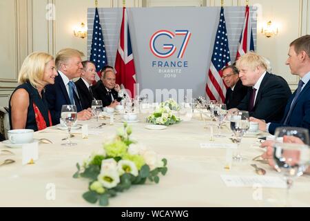 Stati Uniti Presidente Donald Trump, sinistra, detiene una colazione di lavoro con il Primo Ministro britannico Boris Johnson e le loro delegazioni a margine del vertice del G7 l'Hotel du Palais Biarritz Agosto 25, 2019 a Biarritz, Francia. Foto Stock