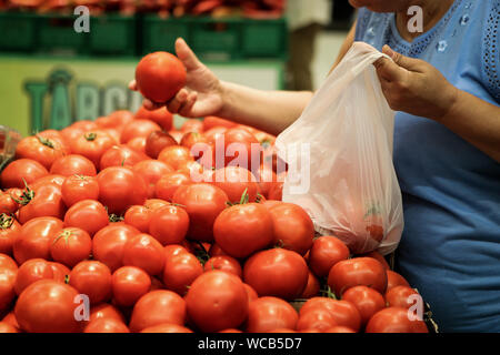 Una donna utilizza plastica biodegradabile sacchi alimentari per comprare frutta e verdura dal supermercato Foto Stock