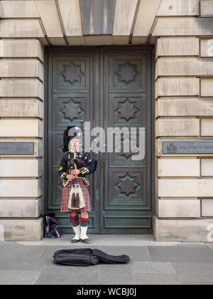 Uno scozzese indossando il tradizionale abito scozzese giocando le cornamuse lungo il Royal Mile sulla luglio 26, 2017 a Edimburgo, Scozia. Ci sono molti piper Foto Stock