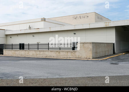 Un contorno sbiadito di un logo segno esterno di una chiusa e abbandonata Sears store di Mentor, Ohio, 11 agosto 2019. Foto Stock