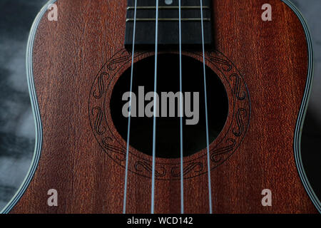 Ukulele closeup. Luminose e sfondo astratto. I dettagli. Foto Stock