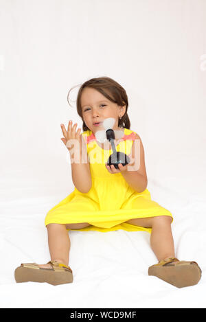 Bambina con un giocattolo di plastica ventola Foto Stock