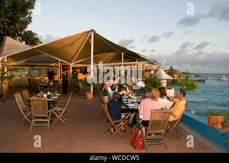 I turisti in un ristorante con vista sul mare, tramonto al capitano Don's Habitat, famoso resort e Diving hotel, Kralendijk, Bonaire, Antille olandesi Foto Stock