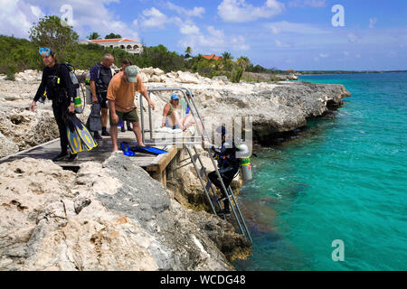 Shore, immersioni scuba diver entra in mare su un ledder, la maggior parte dei siti di immersione sono raggiungibili da riva, Bonaire, Antille olandesi Foto Stock