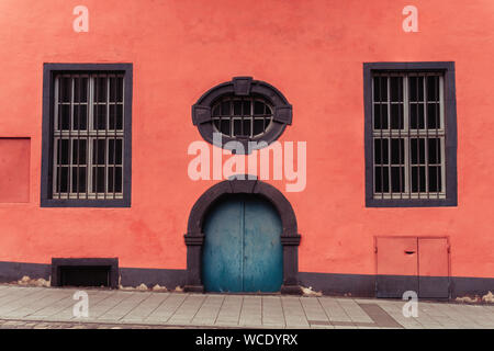 Sfondo grunge di arco di porte e finestre sul rosso antico muro dell'edificio storico. Foto Stock