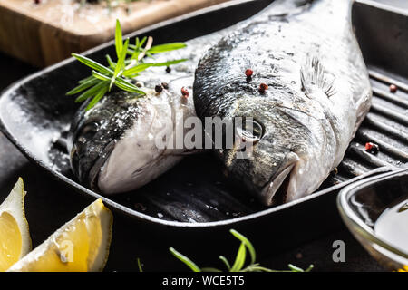 Pesce del Mediterraneo pagello con spezie sale erbe aglio e limone. Pesce sano. Concetto di sano cibo del mare Foto Stock