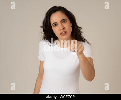 Close up di giovani frustrati attraente donna latina nel sottolineare con la furiosa faccia. Guardando mad e deluso compiendo gesti arrabbiato. In backgr neutrale Foto Stock