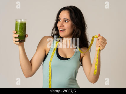 Centro fitness donna sorridente felice con piano di dieta per perdere peso; esercizio e verde frullato vegetale bibita salutare. In bellezza la cura del corpo, Health Fitness D Foto Stock