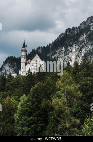 Vista verticale dal villaggio di Hohenschwangau sul castello di Neuschwanstein - famoso in Europa e punto di riferimento tedesco in stile Revival romanico arch Foto Stock