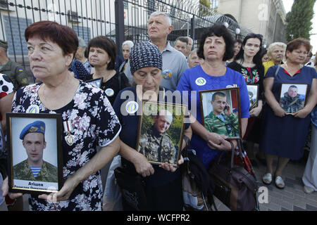Kiev, Ucraina. 28 Agosto, 2019. Parenti tenere i ritratti di ucciso soldati ucraini, che erano stati persi in combattimenti nei pressi della città Ilovaysk cinque anni fa durante un rally di fronte l'Ambasciata russa a Kiev in Ucraina, il 28 agosto 2019. Gli ucraini riuniti in memoria di perdita di soldati ucraini, marcatura segna il quinto anniversario della lotta in Ilovaysk. Secondo l'Ucraina funzionari, 366 soldati ukrainiens sono state perse e 158 erano mancanti durante i pesanti combattimenti tra il governo ucraino e le forze pro-russo separatisti nei pressi di Ilovaysk ad agosto 2014 in Ucraina orientale. (Credito Immagine: © Serg Gl Foto Stock