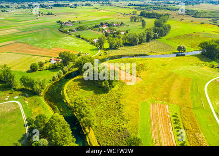Bellissimo fiume Gacka che scorre tra gli alberi e i campi, summer view, Lika regione della Croazia, drone volando sopra la superficie del fiume Foto Stock