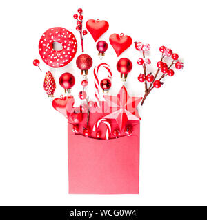 Regalo di natale concetto. Biglietto di auguri con decorazioni rosso in busta rossa su sfondo bianco Foto Stock