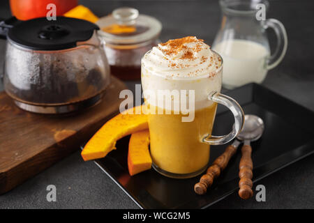 Un bicchiere di vetro di zucca piccante latte su sfondo scuro Foto Stock