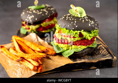 Due vegan black hamburger con patatine fritte di patate dolci Foto Stock