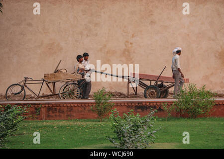 Lavoratori utilizzano metodi tradizionali pur tendendo i giardini di Itimad-ud-Daulah tomba (Baby Taj), al tramonto, Agra, Uttar Pradesh, India, Asia centrale Foto Stock