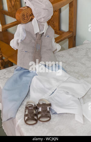 Greco Ortodosso di oggetti di battesimo - baby vestiti, scarpe, battesimo olio, sapone e candele Foto Stock