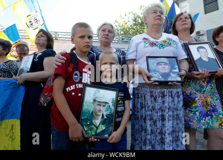 Kiev, Ucraina. 28 Agosto, 2019. Parenti tenere le foto degli uomini delle forze armate ucraine che erano stati uccisi nella lotta all'Ilovaysk battaglia durante un rally di fronte l'Ambasciata russa a Kiev.ucraini segnare il quinto anniversario della battaglia Ilovaysk a est dell'Ucraina, e raccolte in memoria di perso i soldati ucraini. Secondo l'Ucraina funzionari, 366 soldati ukrainiens sono andati persi e 158 erano mancanti durante i pesanti combattimenti tra il governo ucraino forze e russo-backed separatisti all'Ucraina orientale nei pressi della città Ilovaysk in agosto 2014. Credito: SOPA Immagini limitata/Alamy Live News Foto Stock