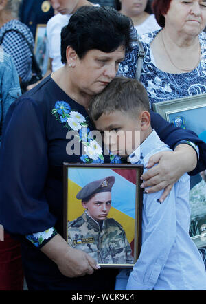 Kiev, Ucraina. 28 Agosto, 2019. Parenti tenere le foto degli uomini delle forze armate ucraine che erano stati uccisi nella lotta all'Ilovaysk battaglia durante un rally di fronte l'Ambasciata russa a Kiev.ucraini segnare il quinto anniversario della battaglia Ilovaysk a est dell'Ucraina, e raccolte in memoria di perso i soldati ucraini. Secondo l'Ucraina funzionari, 366 soldati ukrainiens sono andati persi e 158 erano mancanti durante i pesanti combattimenti tra il governo ucraino forze e russo-backed separatisti all'Ucraina orientale nei pressi della città Ilovaysk in agosto 2014. Credito: SOPA Immagini limitata/Alamy Live News Foto Stock