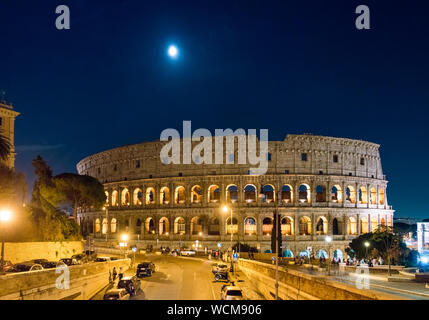 Vista notturna del Colosseo a Roma, Italia con gibous calante luna su di esso Foto Stock