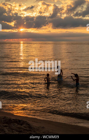 Unione Pier, Michigan - giocare i bambini mentre il sole tramonta sul Lago Michigan. Foto Stock