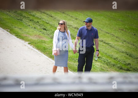 Zagabria, Croazia - 28 Maggio 2019 : Coppia felice con la donna è incinta tenendo le mani insieme mentre si cammina sul sentiero. Foto Stock