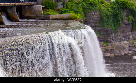 Un fragore cascata scende whitewater giù in un dirupo, appena al di là di una diga. Foto Stock