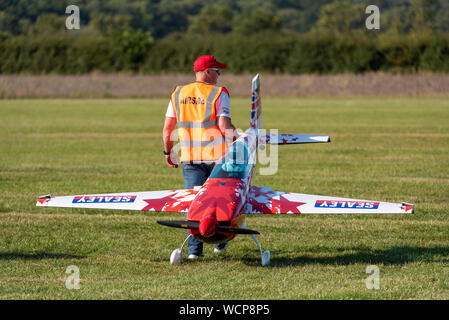 Mike Williams con il modello in scala 300 Extra aereo acrobatico prima di prendere parte a piccoli e grandi Formazione presso il piccolo Gransden Aria & Car Show, REGNO UNITO Foto Stock