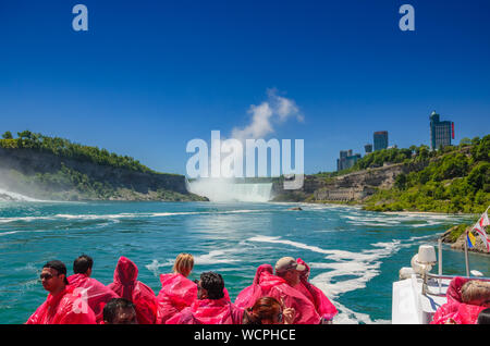 Turisti e visitatori di sperimentare la meraviglia naturale che è le Cascate del Niagara in un nuovo modo, da vicino e dall'acqua su una nave da crociera in Niagara Falls Foto Stock