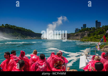 Turisti e visitatori di sperimentare la meraviglia naturale che è le Cascate del Niagara in un nuovo modo, da vicino e dall'acqua su una nave da crociera in Niagara Falls Foto Stock