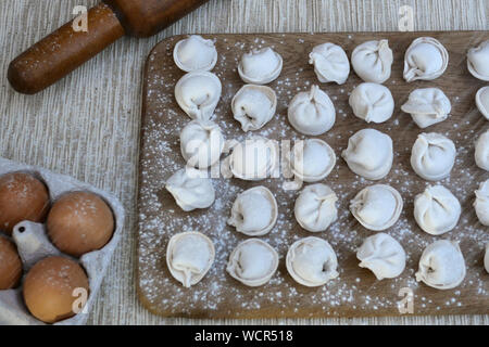 Processo di cottura delle carni in casa gnocchi. Scolpisci gnocchi con carne macinata. Preparare gnocchi fatti in casa su la cucina di bordo, e vengono cosparsi con Foto Stock